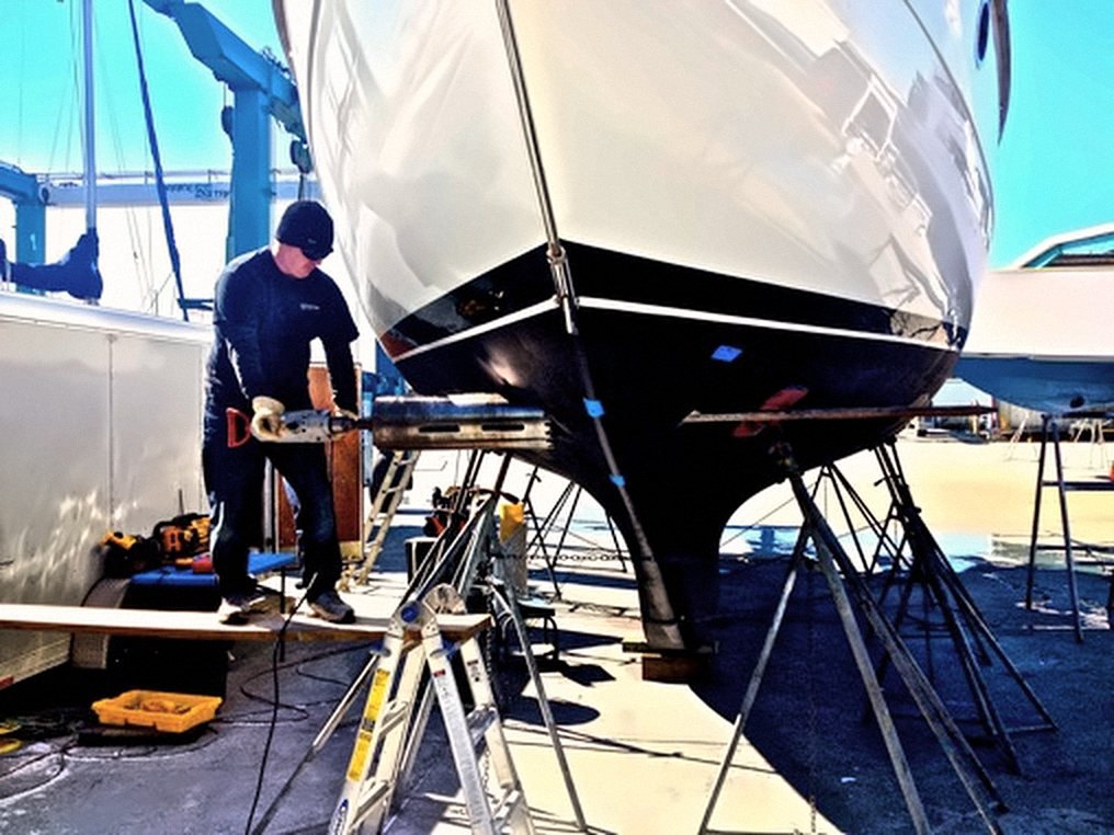 Our tech prepping a sailboat hull on the hard