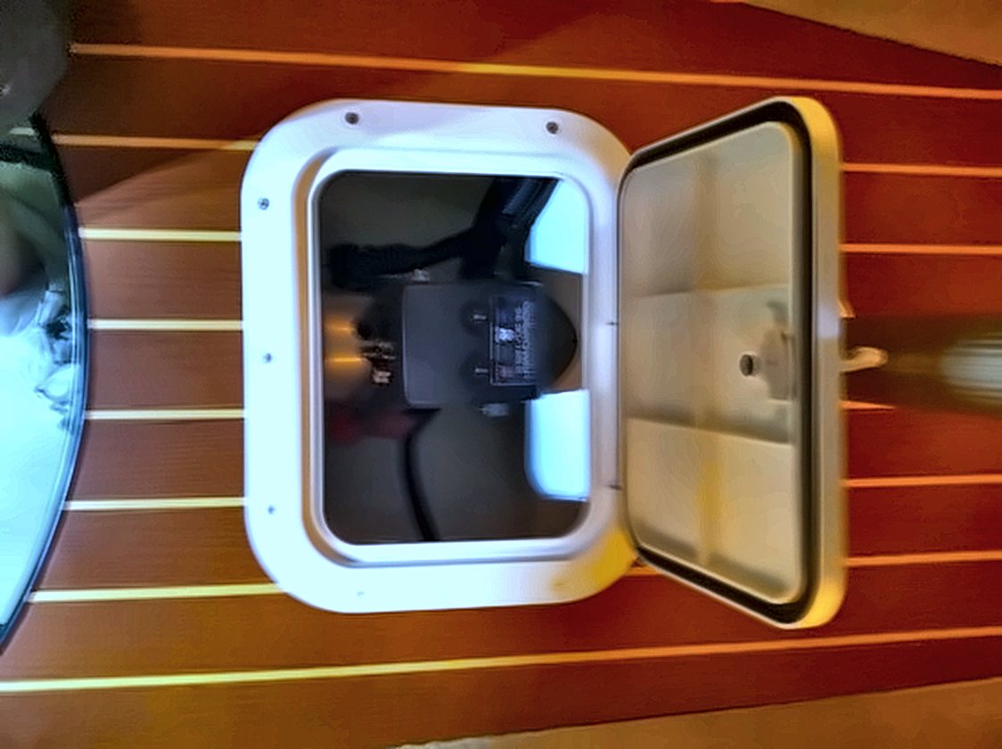 Open teak service hatch showing the thruster motor